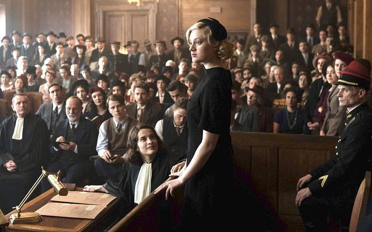 Кадр из фильма «Мое преступление», женщина на скамье подсудимых выступает перед полным залом суда