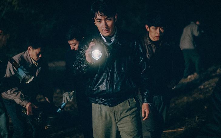 Кадр из фильма «Только течет река»,  следователи с фонариками исследуют поле ночью