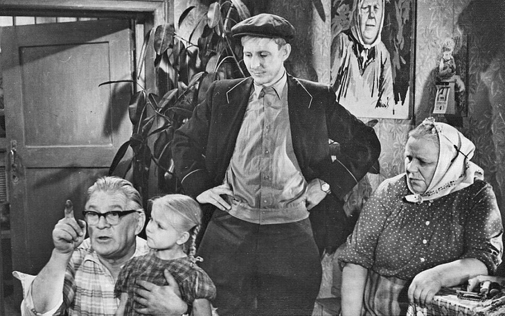 Кадр из фильма «Полустанок», мужчина в кепке стоит в окружении семьи