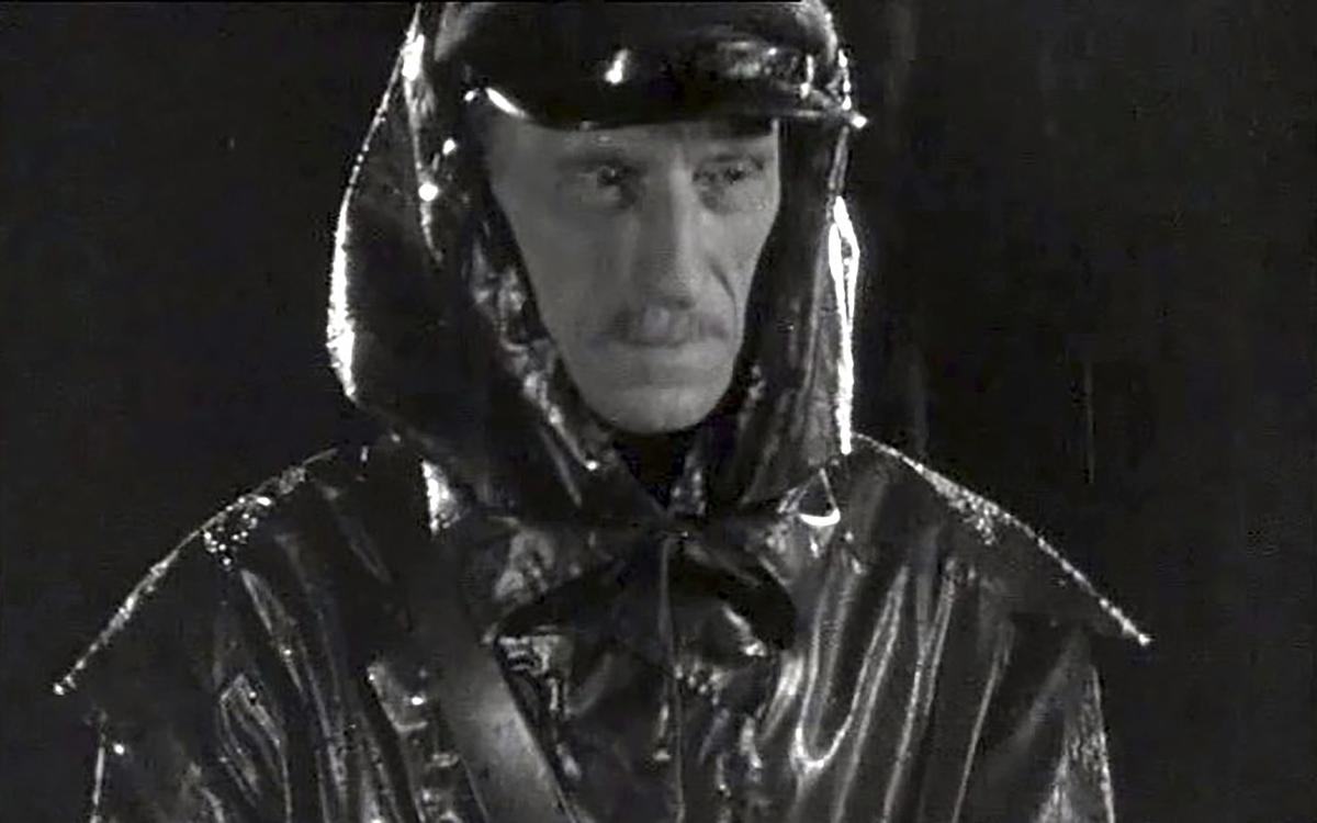 Титульное изображение для страницы события: кадр из фильма «Гибель сенсации», мужчина с усами в фуражке и целлофановом плаще