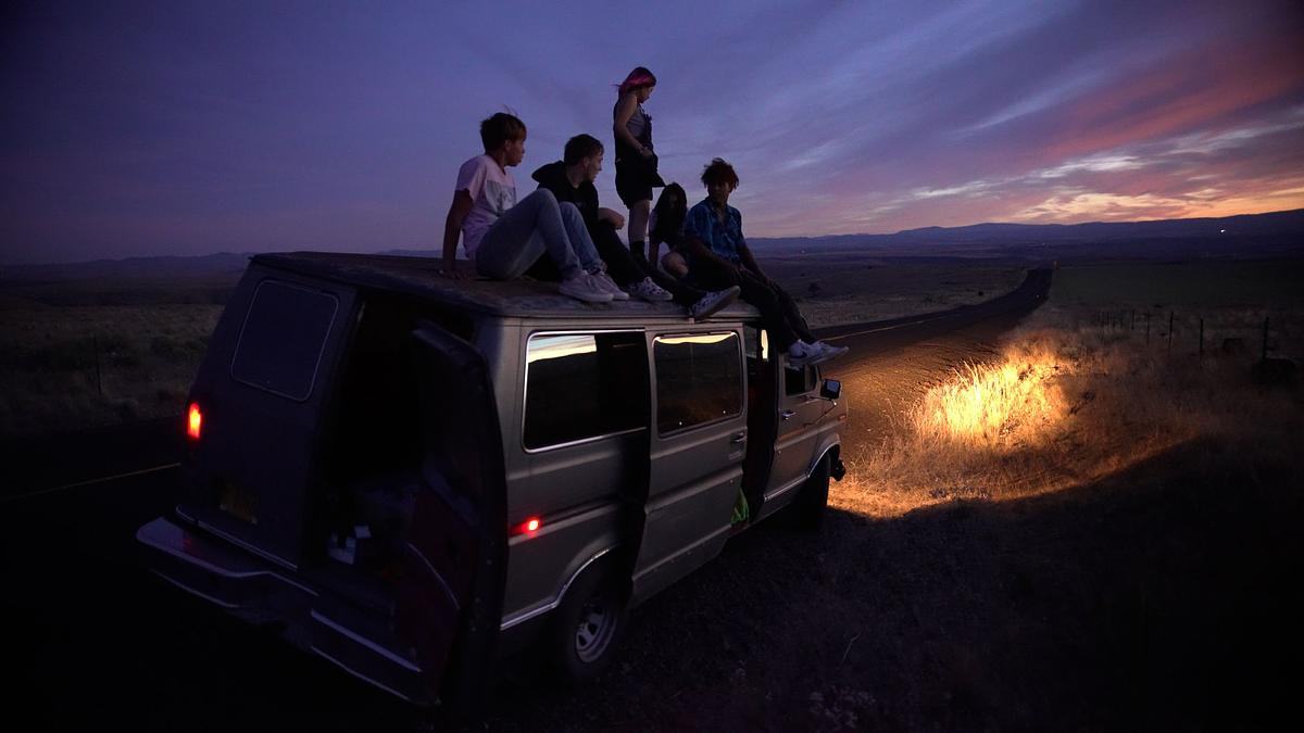 Кадр из фильма «Вечеринка на краю света»,  группа молодых людей на крыше машины едет по степи