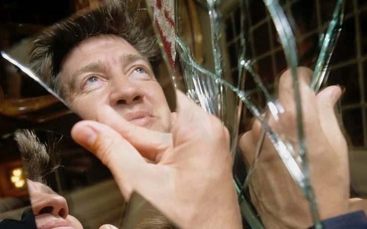 Кадр из фильма «Линч/Оз», рука держит осколок зеркала, в котором отражается Дэвид Линч