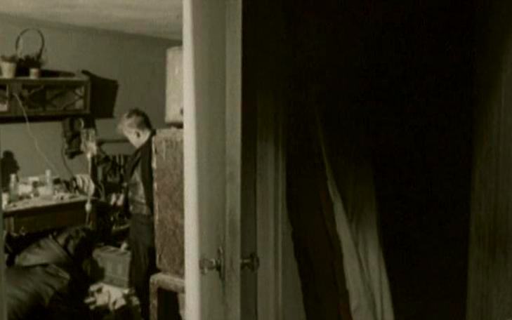 Кадр из фильма «Круг второй», мужчина стоит в комнате за приоткрытой дверью