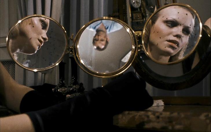 Кадр из фильма «Мир на проводе», три круглых зеркала, в двух отражается женщина, в одном - мужчина