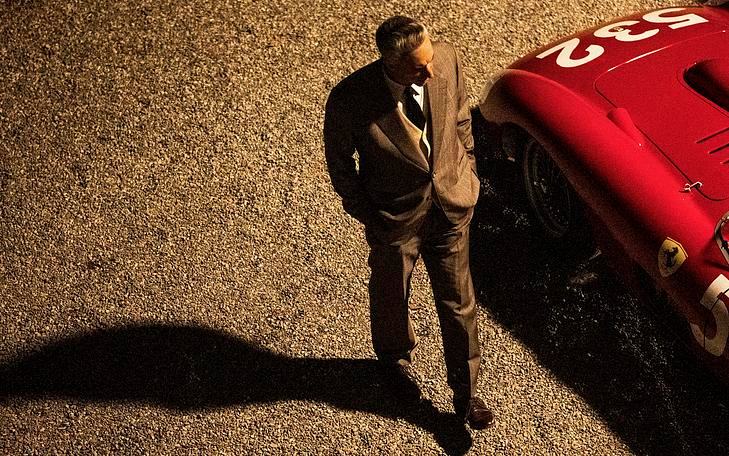 Кадр из фильма «Феррари», мужчина в костюме и с руками в карманах брюк идет вдоль красной спортивной машины