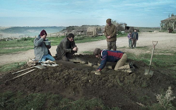 Кадр из фильма «Химера», четыре человека сидят в земле и копают яму