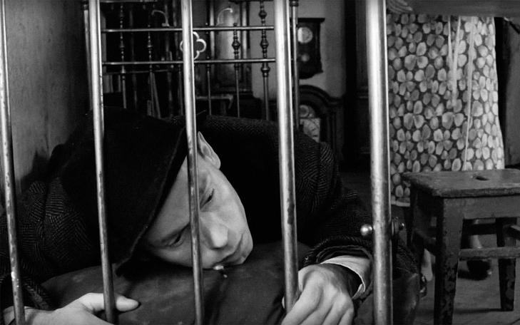 Кадр из фильма «Счастливые дни», мужчина лежит на кровати в одежде