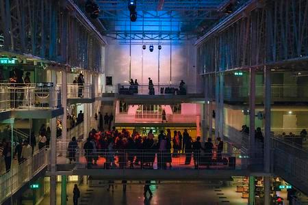 Фотография интерьера Дома культуры «ГЭС-2» с людьми в нем при выключенном освещении