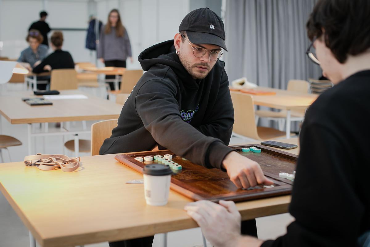 Титульное изображение для страницы события: фотография руки, двигающей фигуру по игровой доске