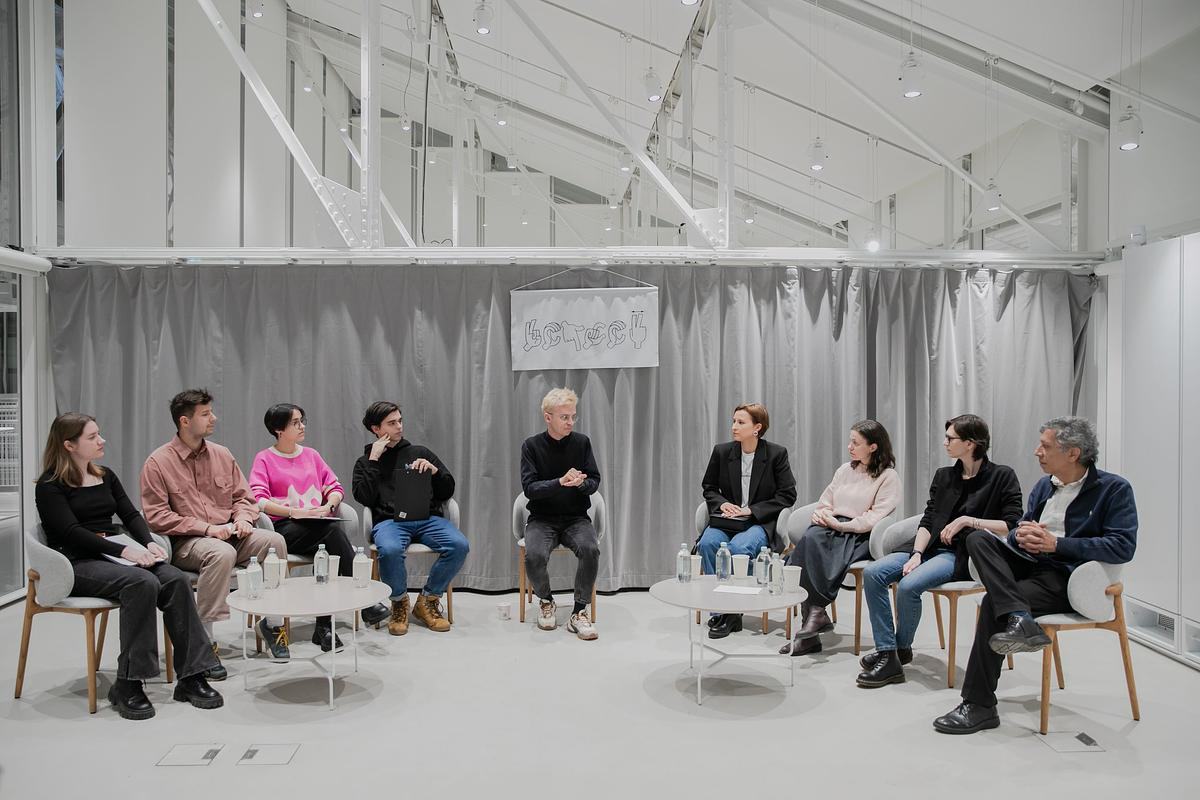 Титульное изображение для страницы события: фото, участники кружка сидят на стульях полукругом и слушают спикера, сидящего по центру