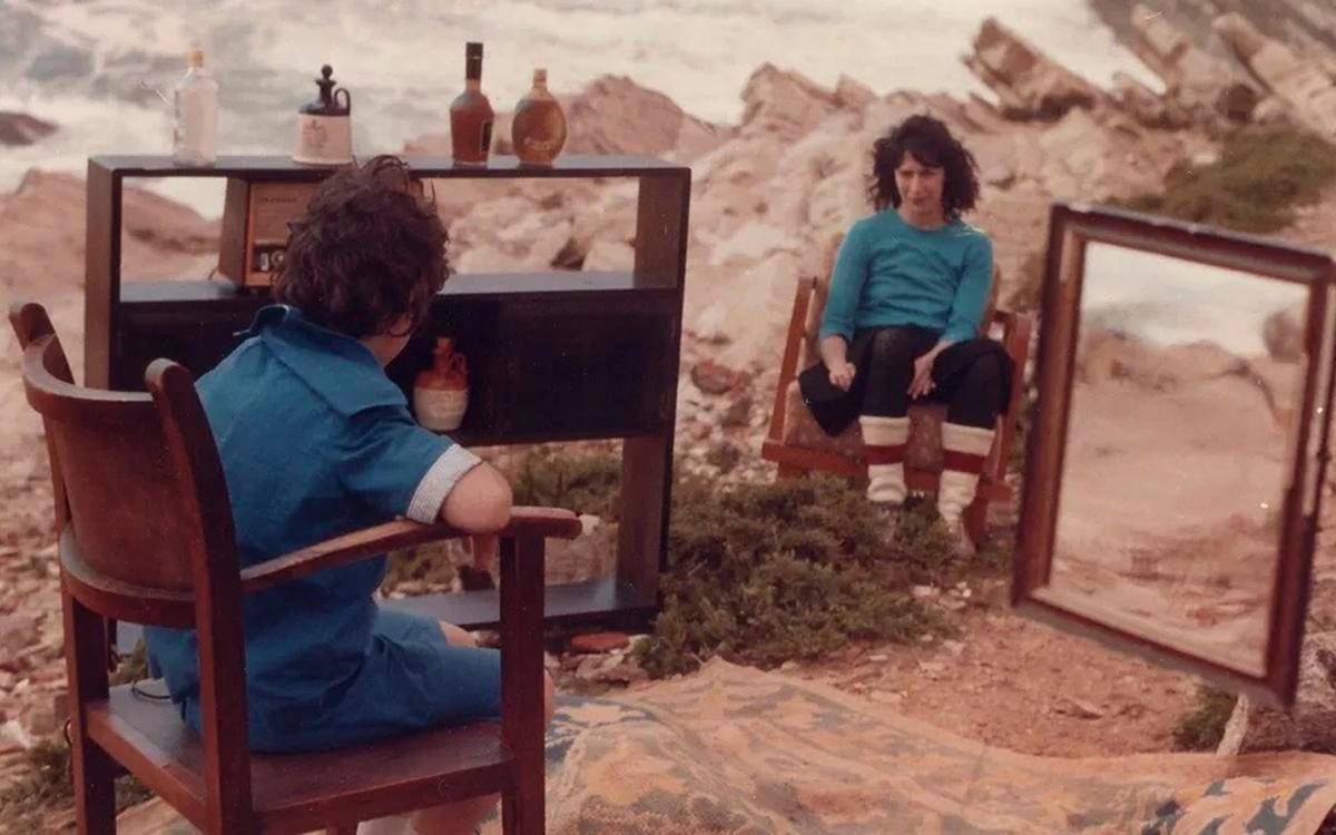 Титульное изображение для страницы события: кадр из фильма «Город пиратов», два человека сидят на стульях в песках, рядом шкаф и зеркало