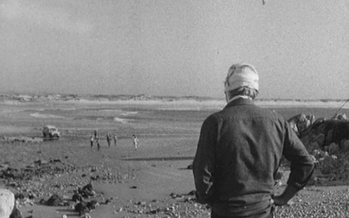 Титульное изображение для страницы события: кадр из фильма «Линия горизонта», человек с перевязанной головой сморит на морское побережье, по которому ходят люди