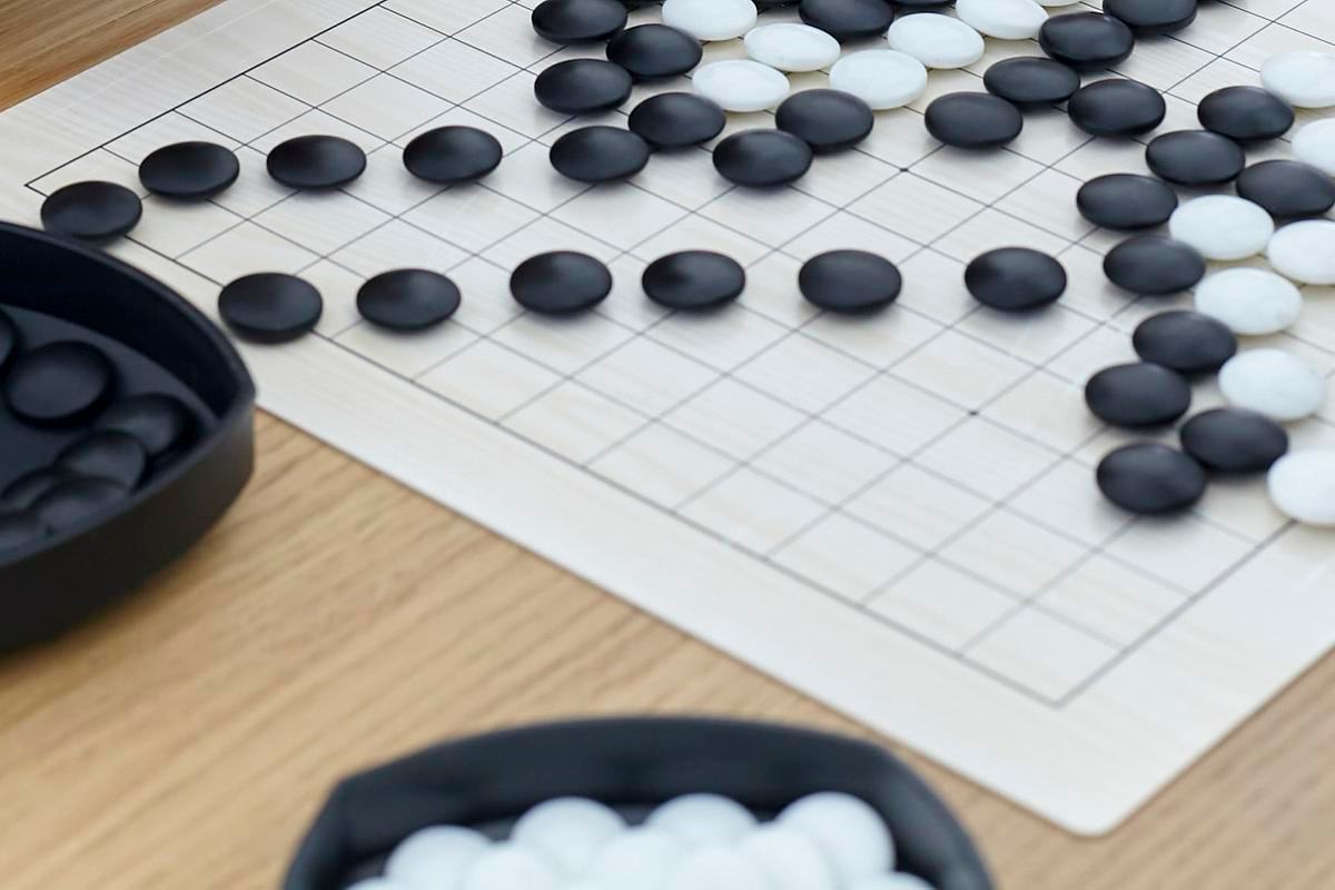 Титульное изображение для страницы события: фотография фрагмента доски для игры в го с черными и белыми камнями