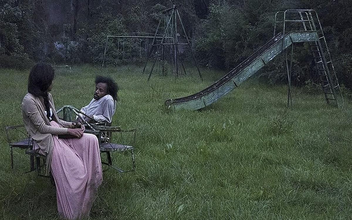 Титульное изображение для страницы события: кадр из фильма «Крошки», мужчина и женщина сидят посреди заброшенной детской площадки