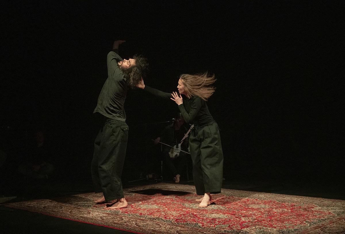 Мужчина и женщина в экспрессивных позах  в танце на ковре
