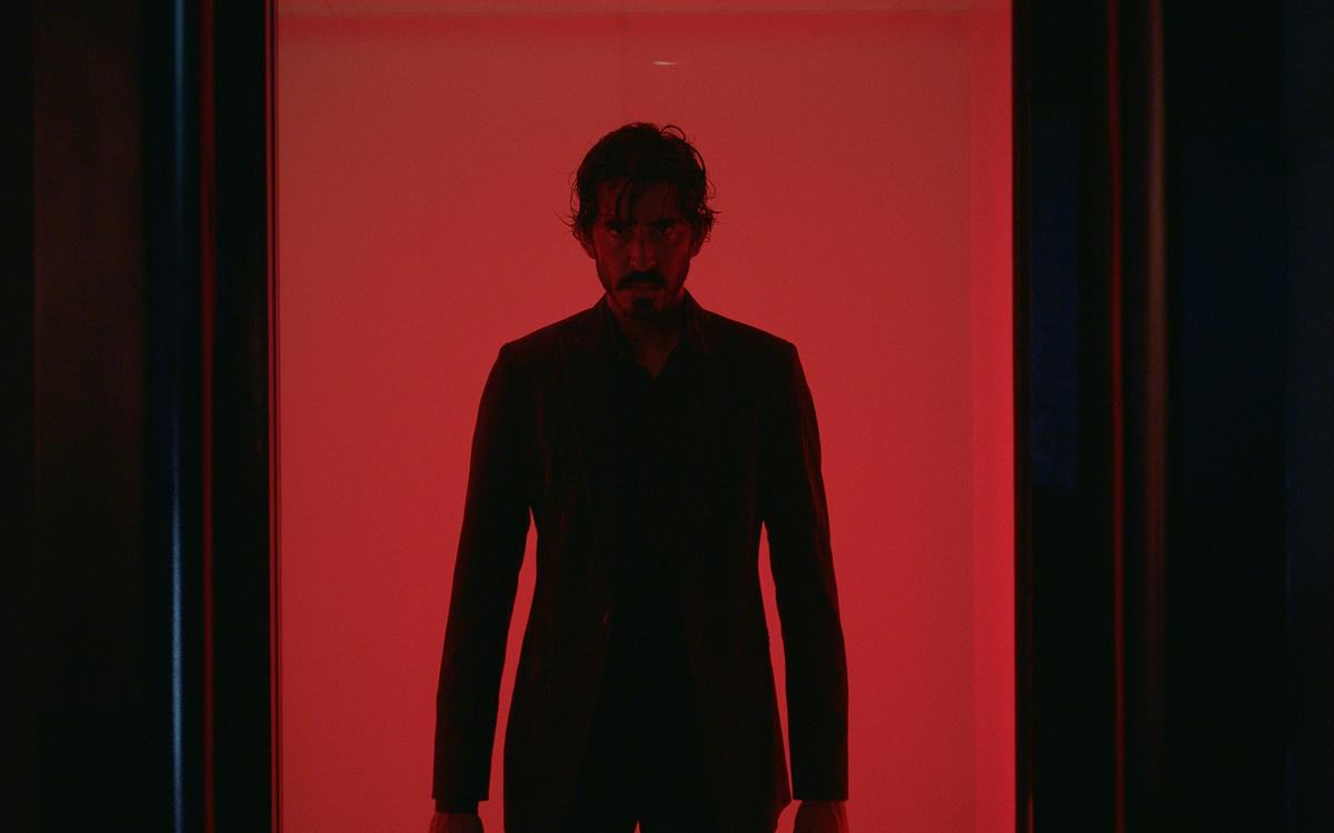 Кадр из фильма «Манкимэн», мужчина в костюме на красном фоне