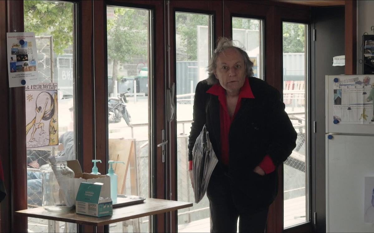 Кадр из фильма «На Адаманте», пожилая женщина с газетой в руках на фоне окна