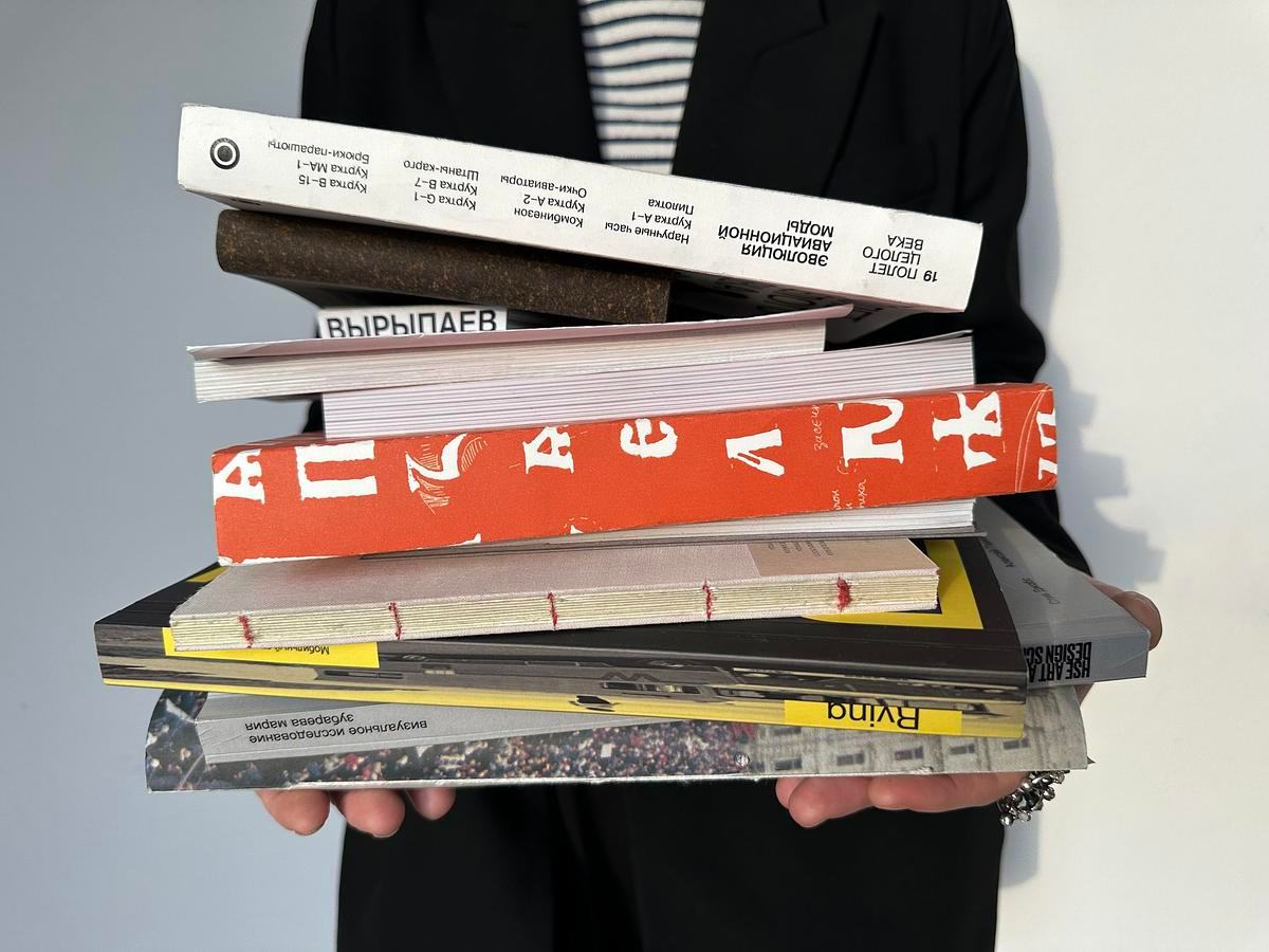 Человек держит в руках стопку книг