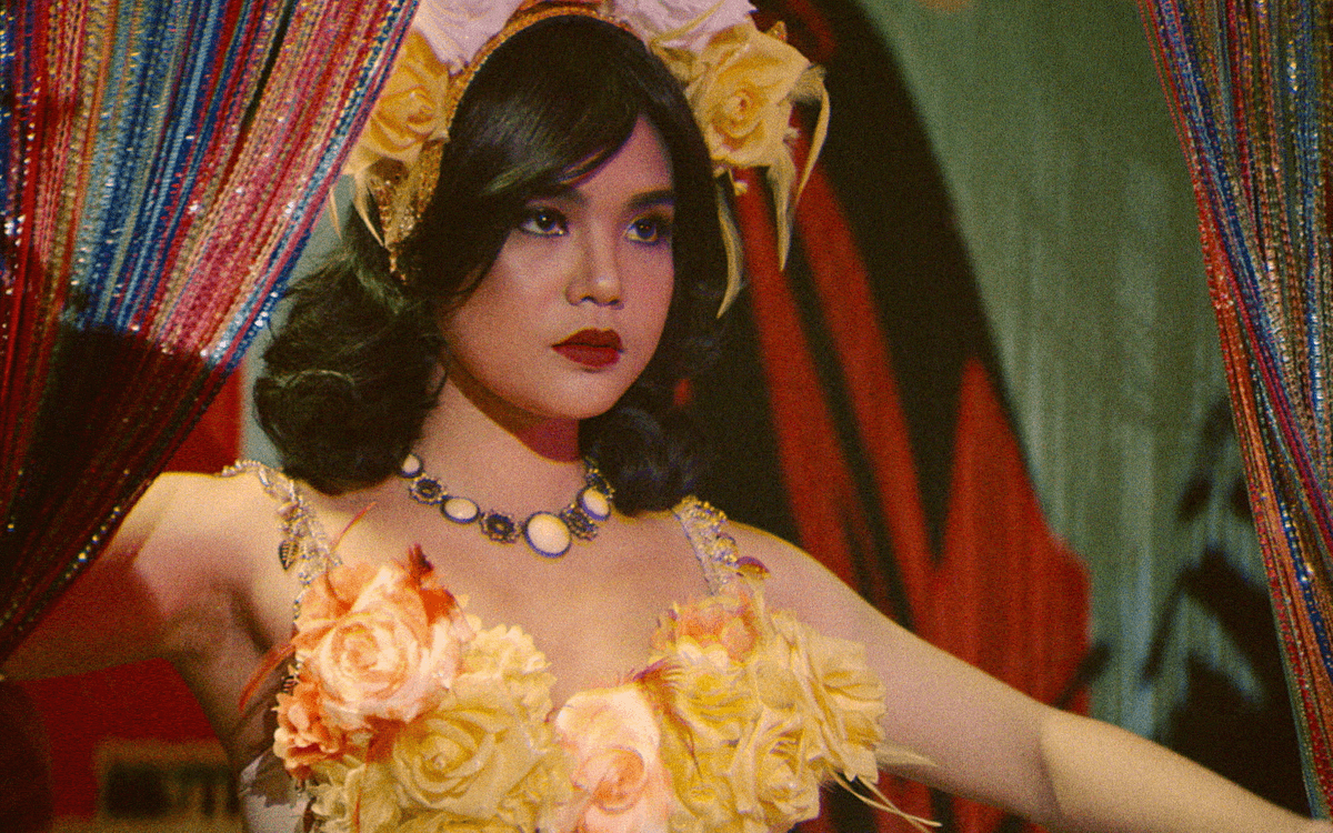 Кадр из фильма «Леонор никогда не умрет», танцовщица в желтом цветочном платье на сцене