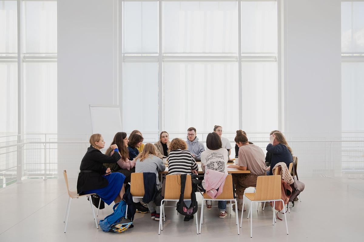 Группа людей сидит за большим столом