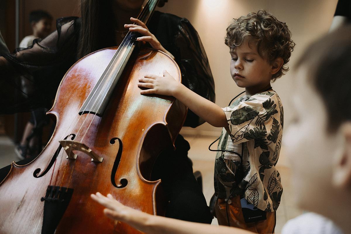 Ребенок трогает виолончель