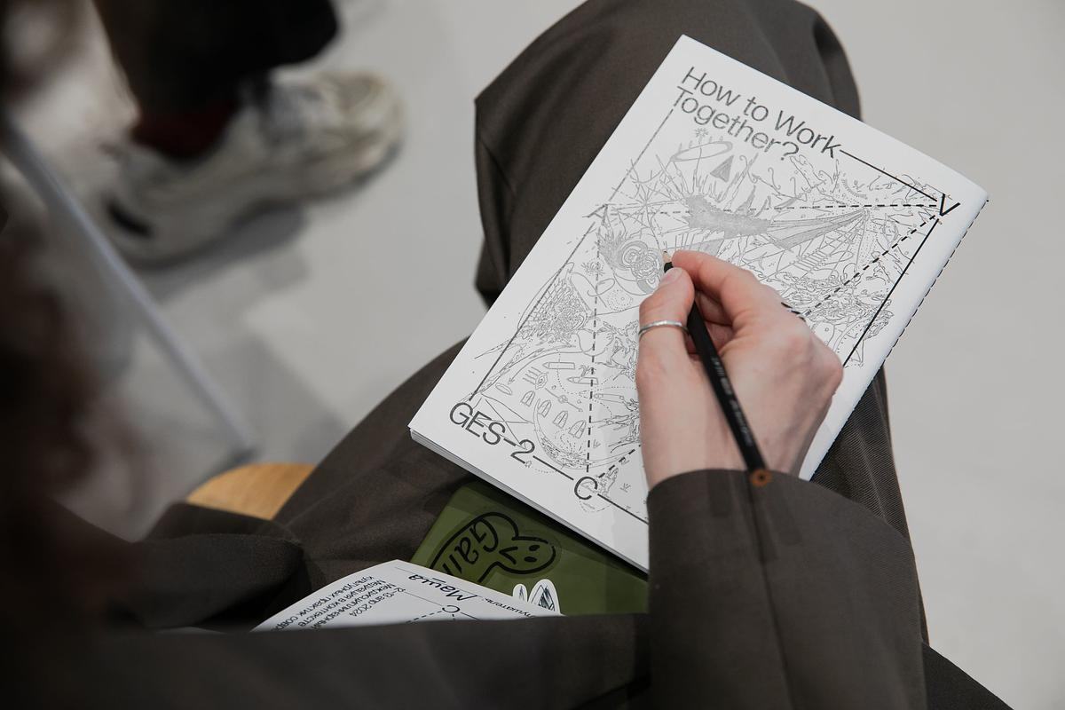 Рука пишет на листе бумаги с рисунком