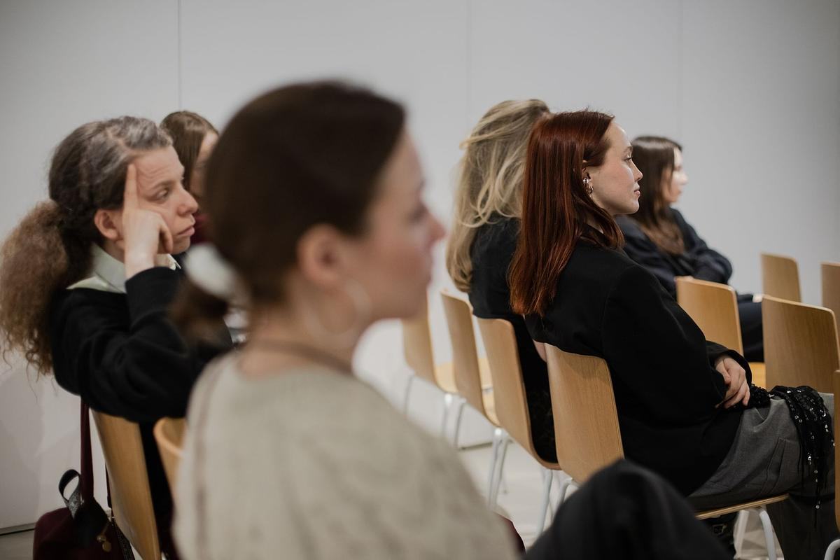 Люди сидят рядами на стальях