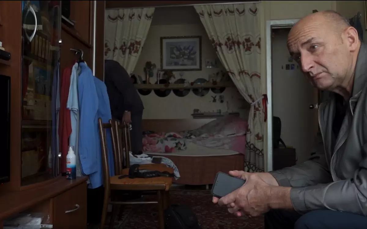 Кадр из фильма «Идеальная тишина», мужчина сидит дома возле шкафа