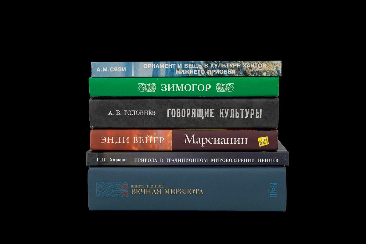 Книги стоят в несколько рядов и лежат стопкой
