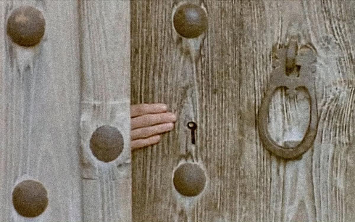 Кадр из фильма «Миг невинности», рука открывает забор