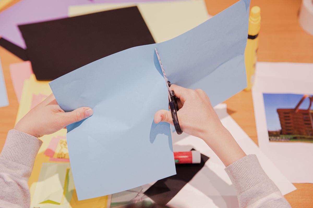 Фото, ребенок режет бумагу на пополам