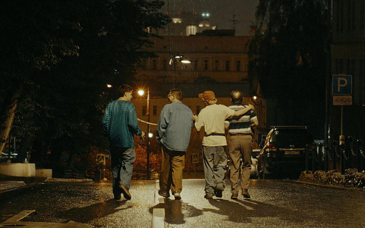 Кадр из фильма «Здесь был Юра», четверо мужчин идут посреди улицы по ночному городу