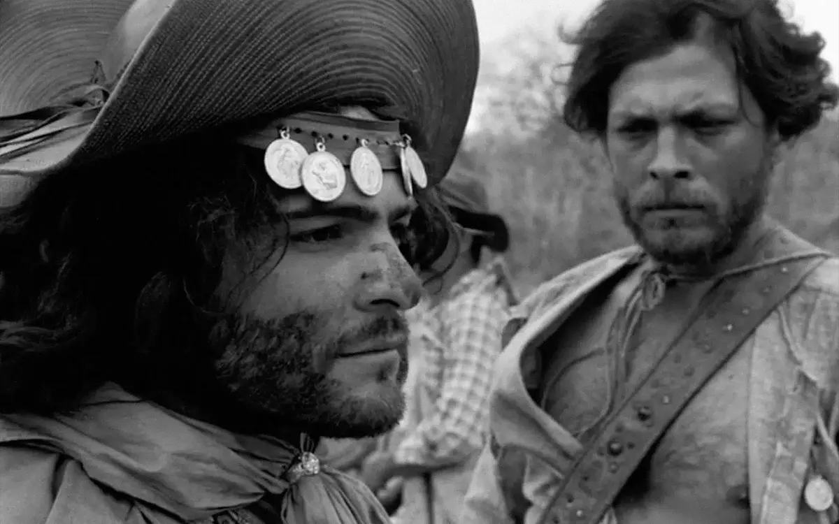 Кадр из фильма «Черный бог, белый дьявол», два мужчины с грязными лицами