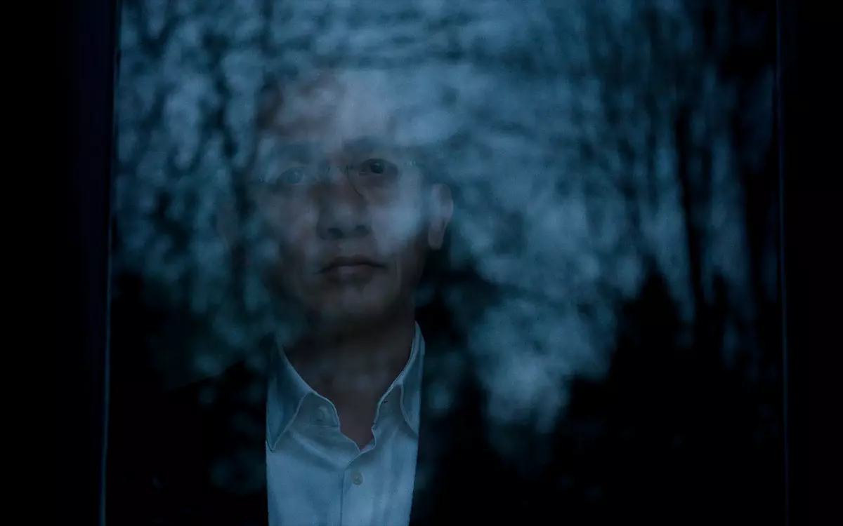 Кадр из фильма «Молчаливый друг», человек смотрит в окно, в котором отражается лес