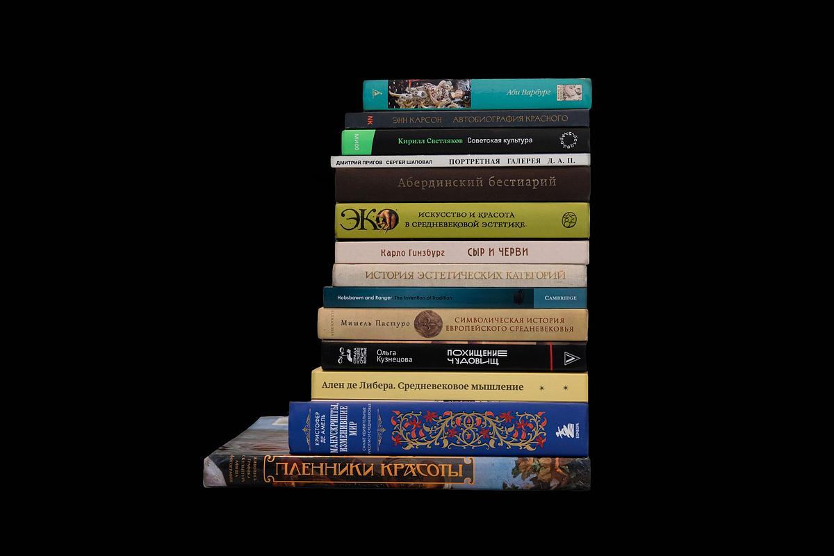 Книги стоят в несколько рядов и лежат стопкой