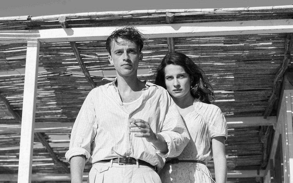 Кадр из фильма «Посторонний», мужчина и женщина на фоне соломенной крыши