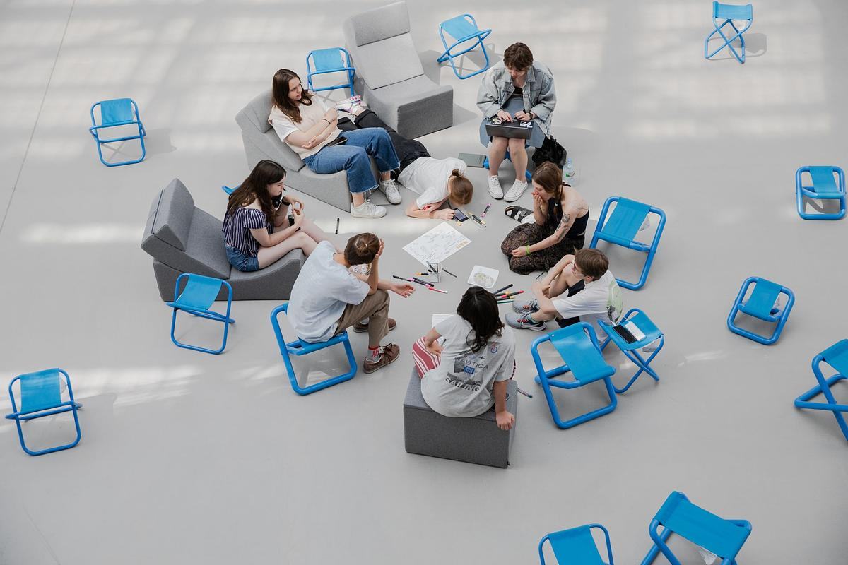 Люди сидят в кругу и рисуют