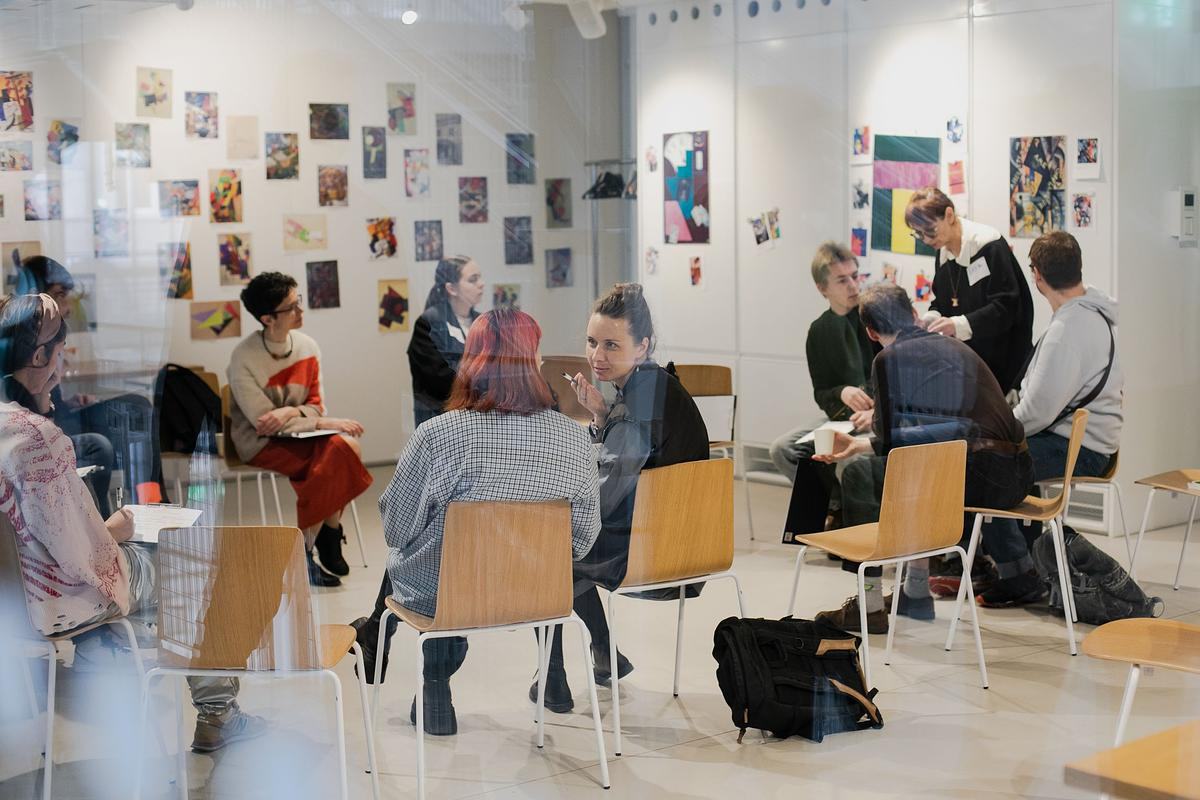 Группы людей общаются сидя на стульях