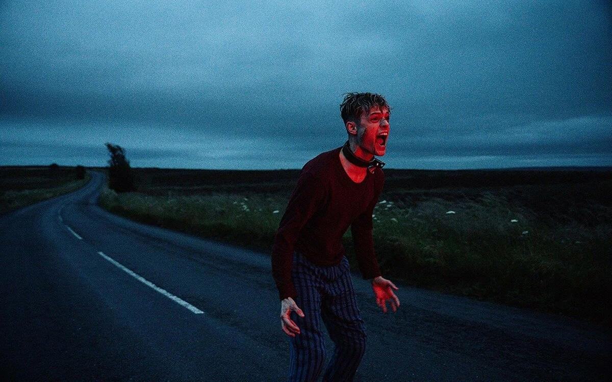 Кадр из фильма «На цепи», человек стоит на трассе и кричит