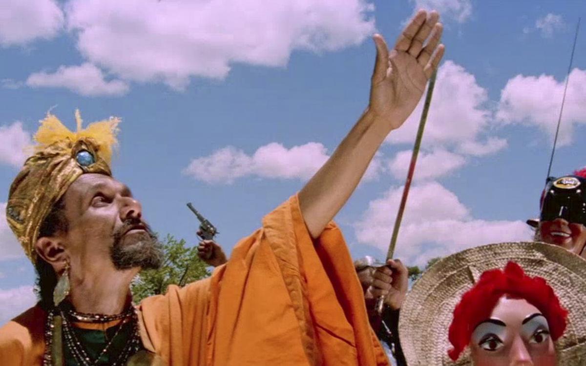 Титульное изображение для страницы события: кадр из фильма «Возраст Земли», мужчина в желтом тюрбане и оранжевом халате вздымает руку вверх