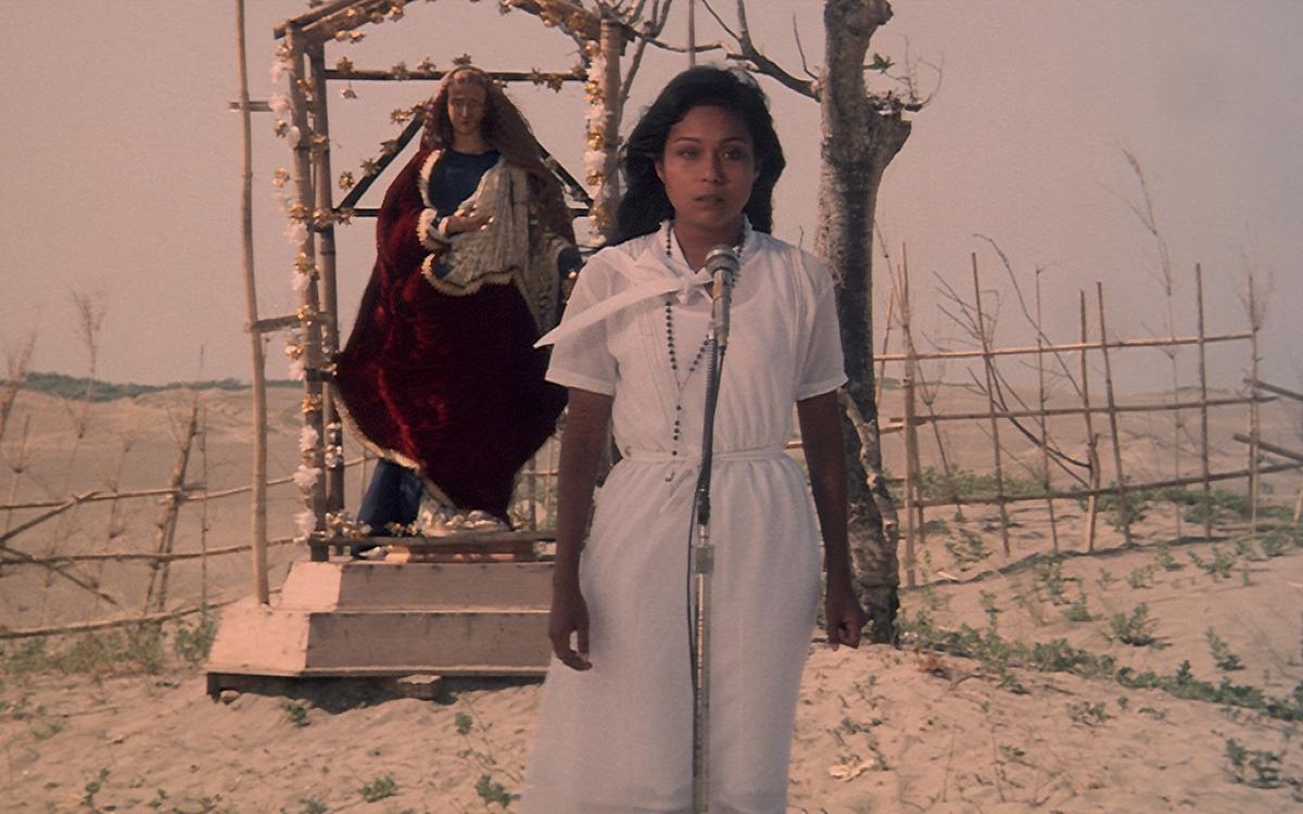 Титульное изображение для страницы события: кадр из фильма «Чудо», женщина в белом стоит  на фоне статуи Девы Марии в пустыне