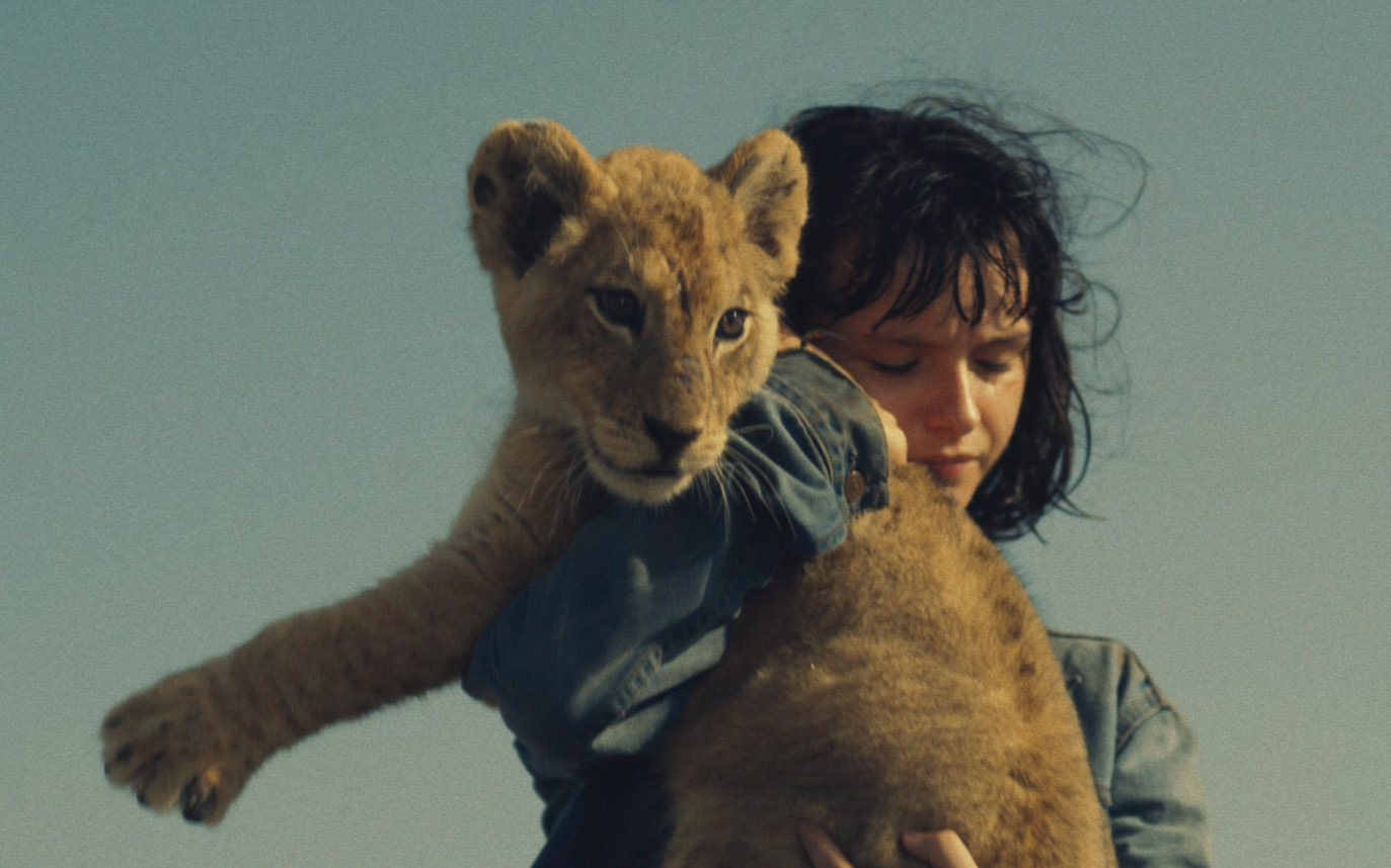 Девочка держит в руках львенка