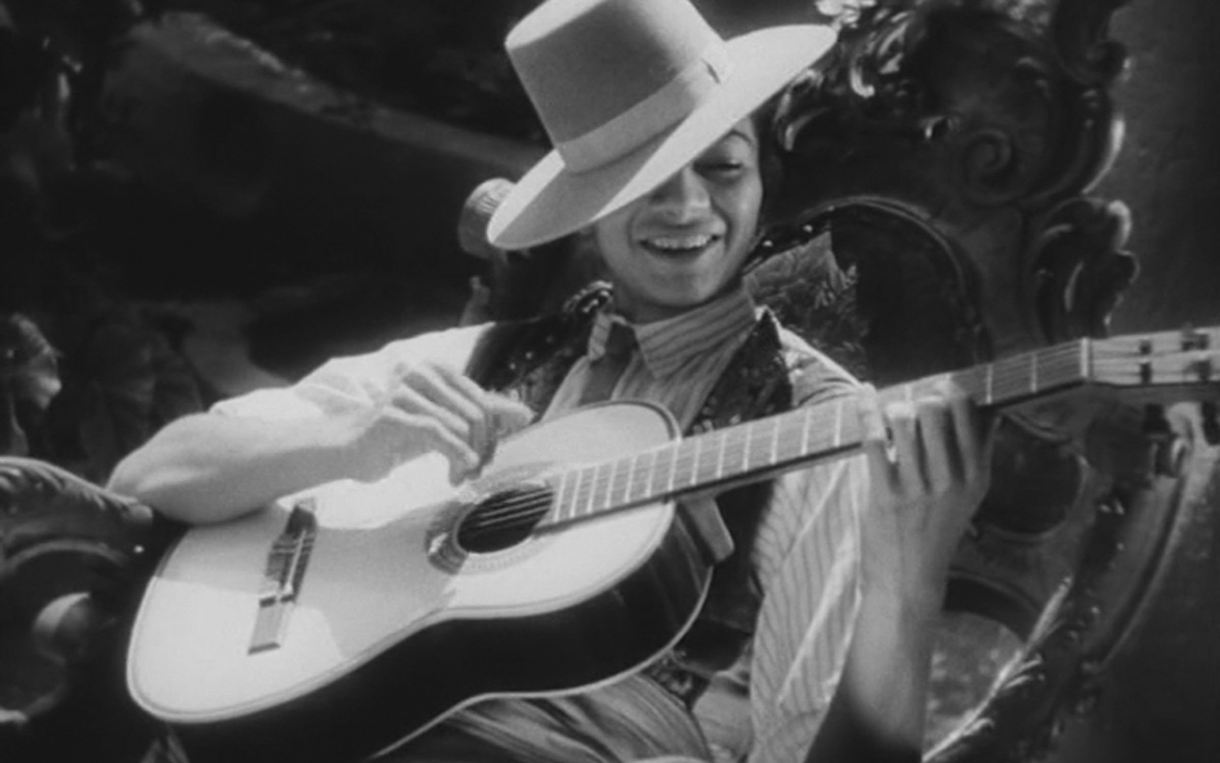 Мужчина в шляпе играет на гитаре