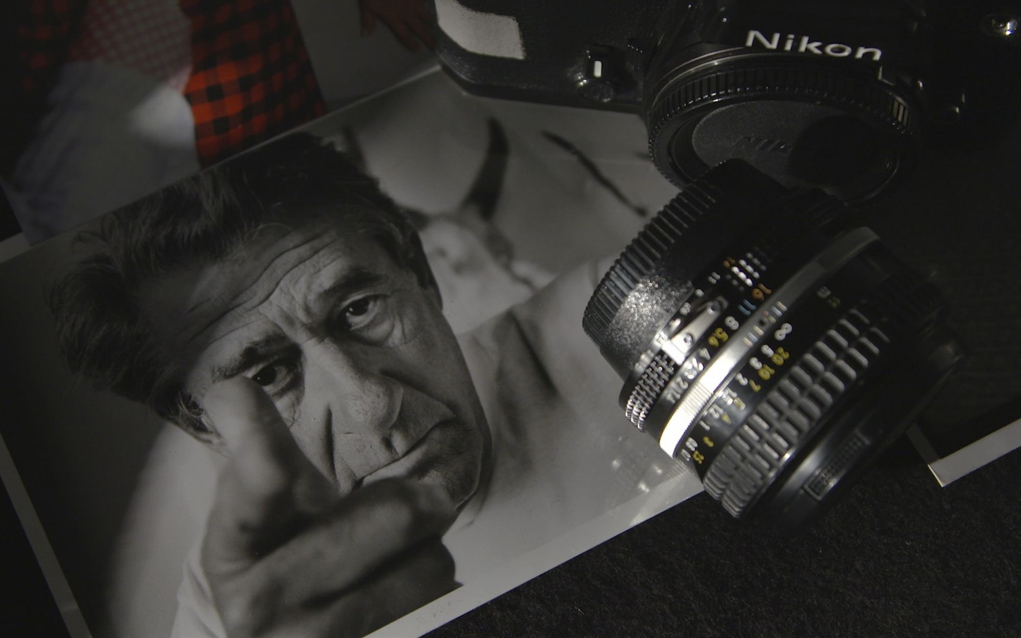 Фотоаппарат лежит поверх черно-белой фотографии с портретом пожилого мужчины
