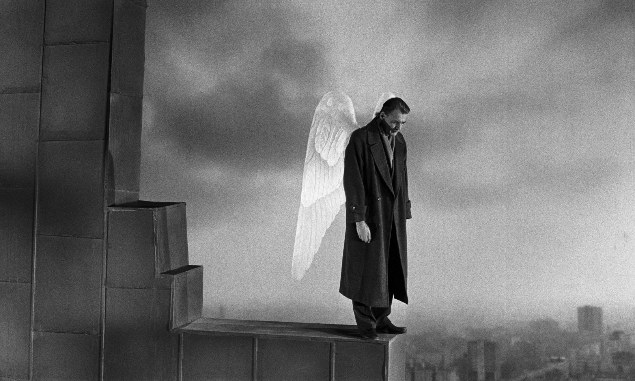 Кадр из фильма «Небо над Берлином», ангел стоит на крыше здания